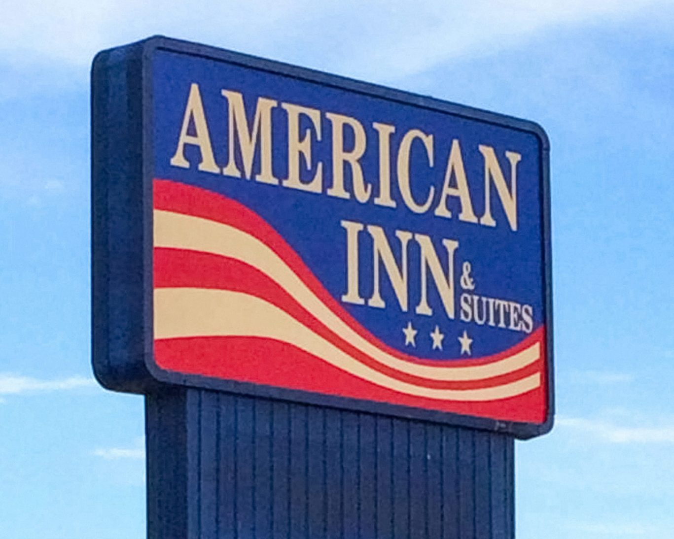 American Inn & Suites roadside sign with patriotic red, white, and blue design.