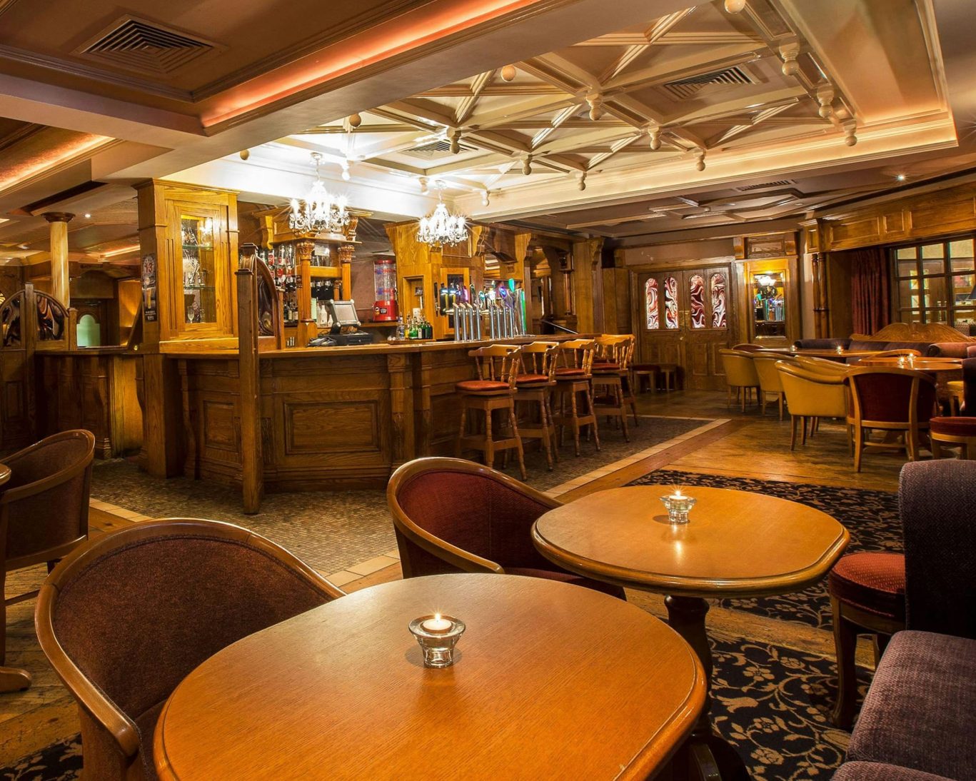 Traditional Irish hotel bar with wooden interiors, chandeliers, and cozy seating at Ardboyne Hotel.
