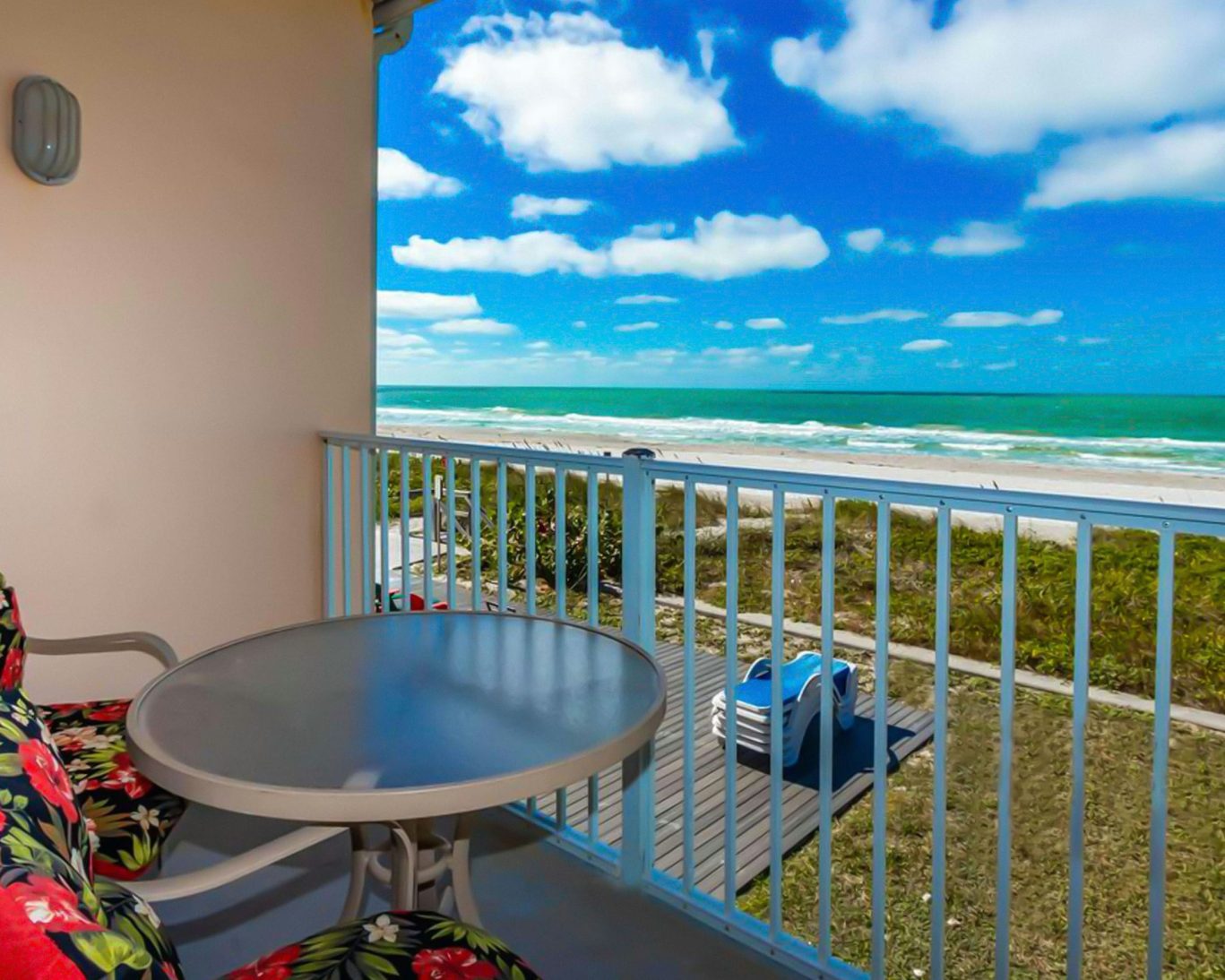 Oceanfront balcony with table and chairs overlooking the beach at Belleair Beach hotel.
