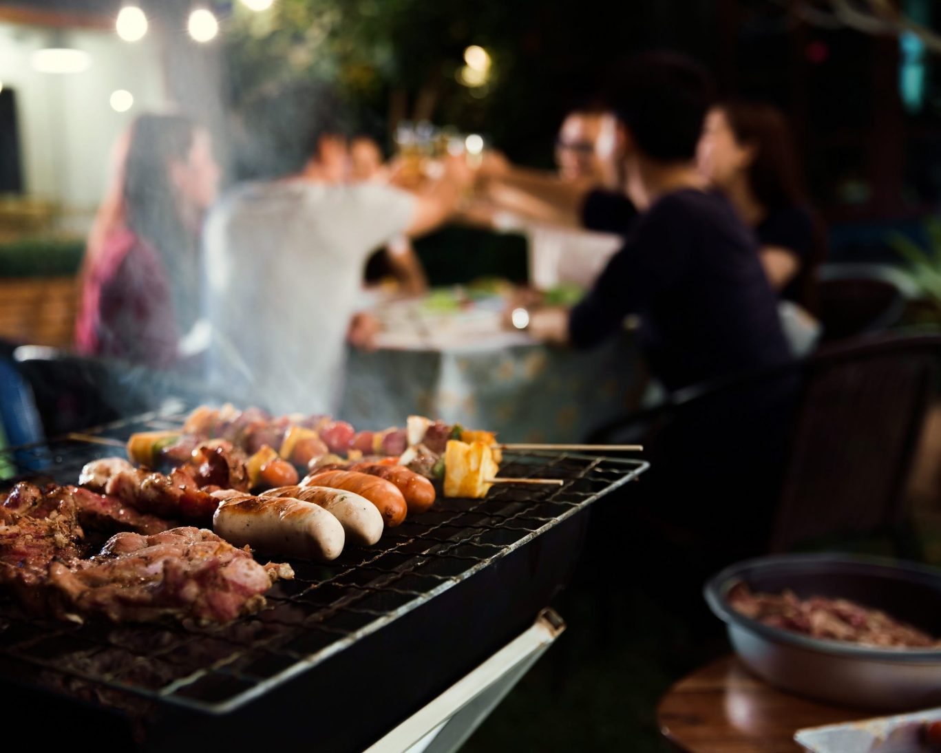 Guests enjoying a barbecue with grilled food and group dining at Belmont Inn & Suites outdoor picnic area.