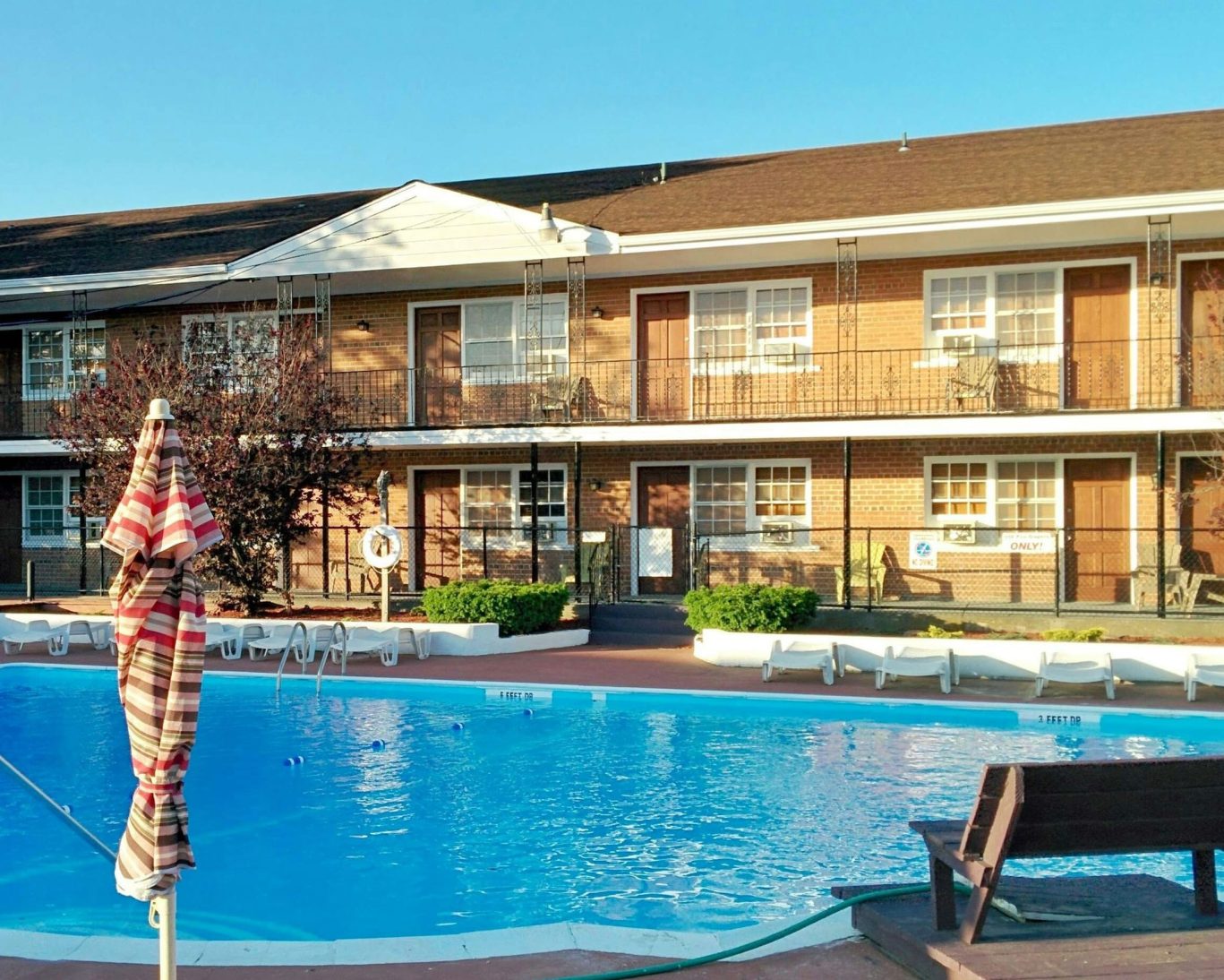Exterior view of Budget Host East End with outdoor pool and sun loungers