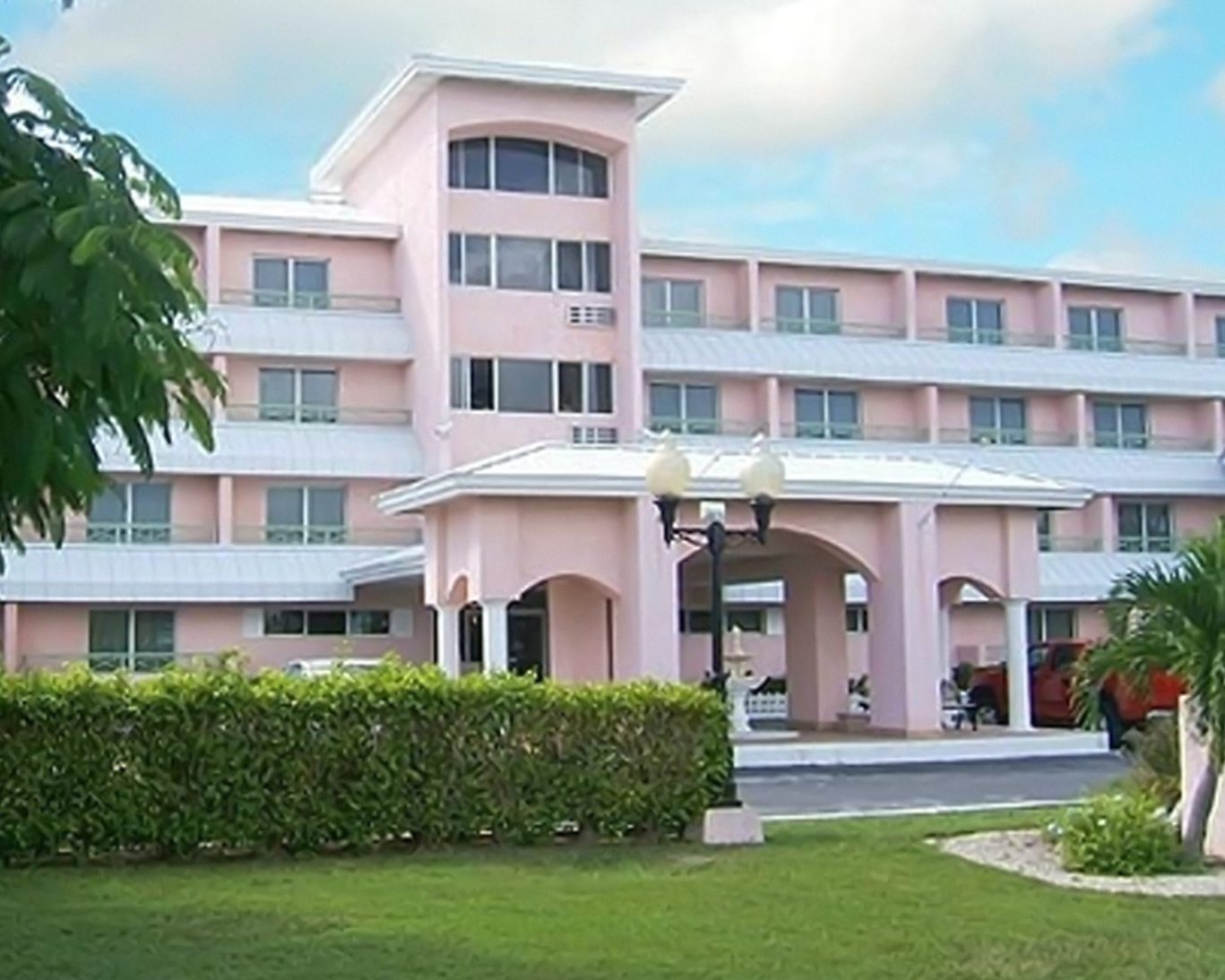 Exterior of Castaways Resort with pink facade and welcoming entrance.