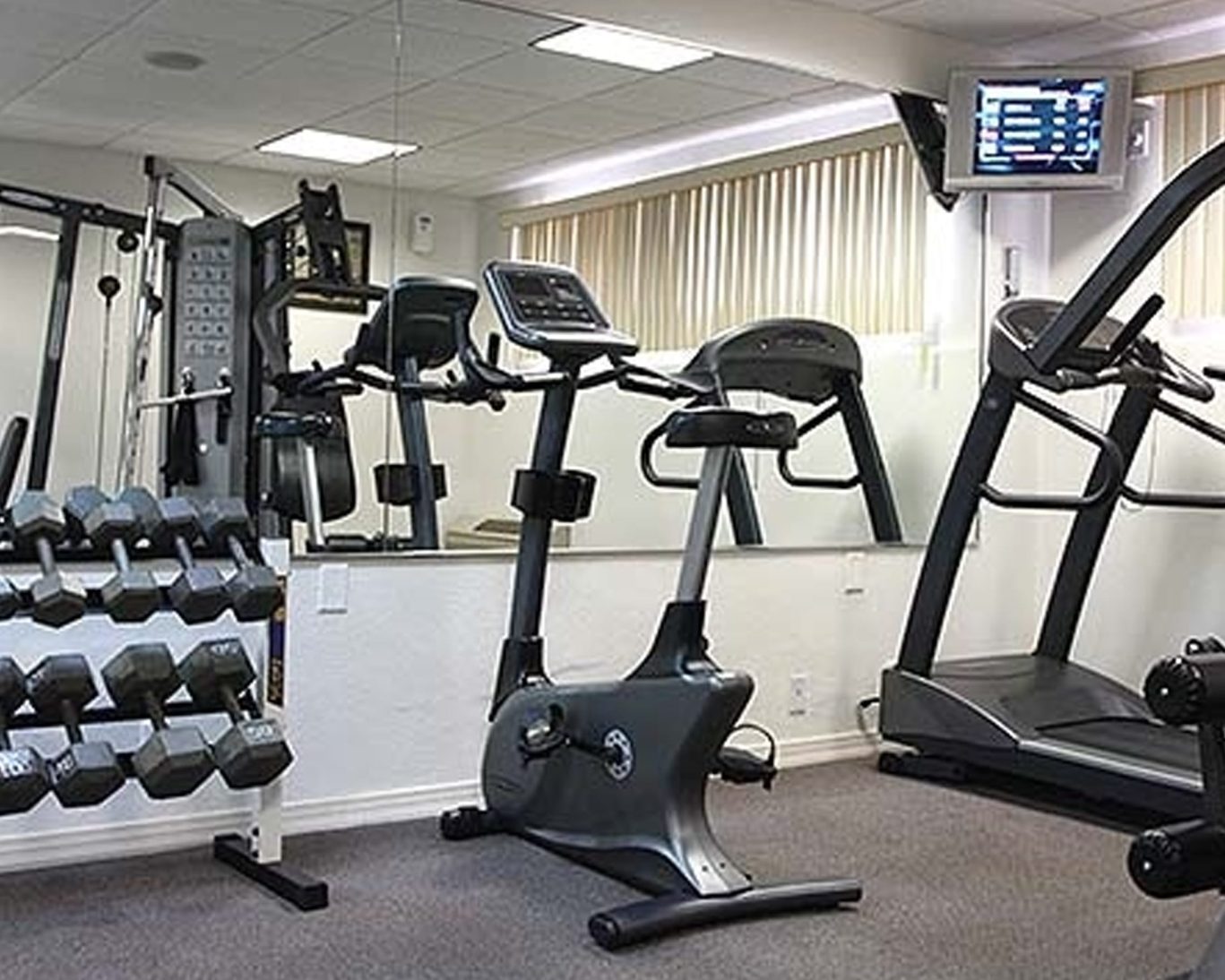 Fully equipped fitness center at Castaways Resort featuring weights, treadmills, and exercise bikes.