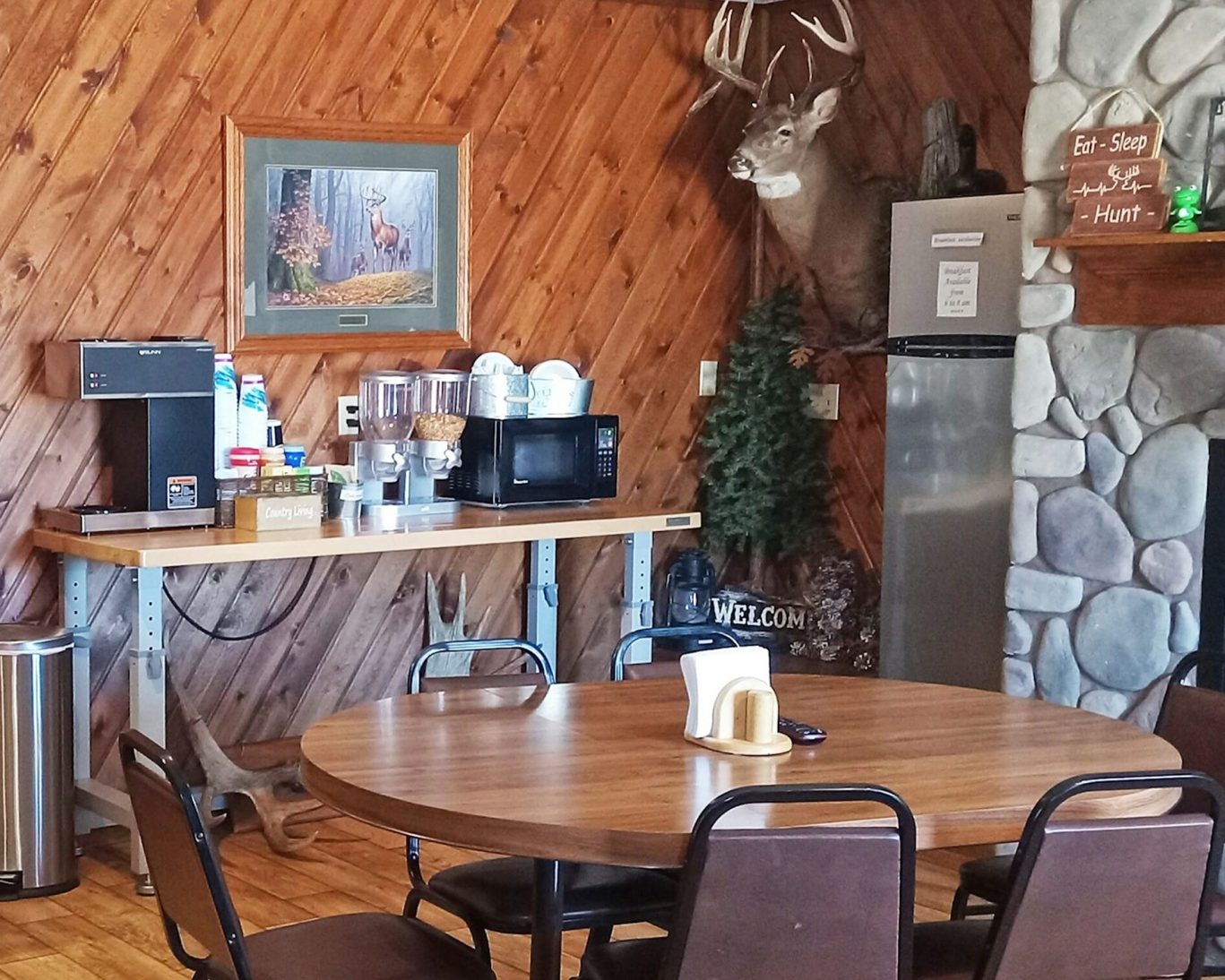 Rustic lodge dining area with hunting décor, deer mount, and complimentary breakfast station.