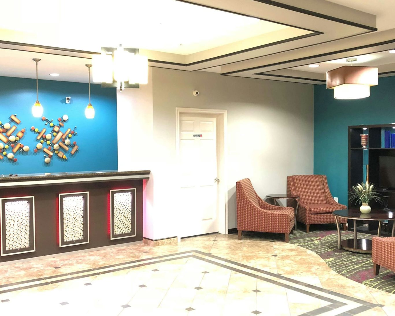 Modern hotel lobby at Executive Inn & Suites featuring stylish reception desk and cozy seating area.