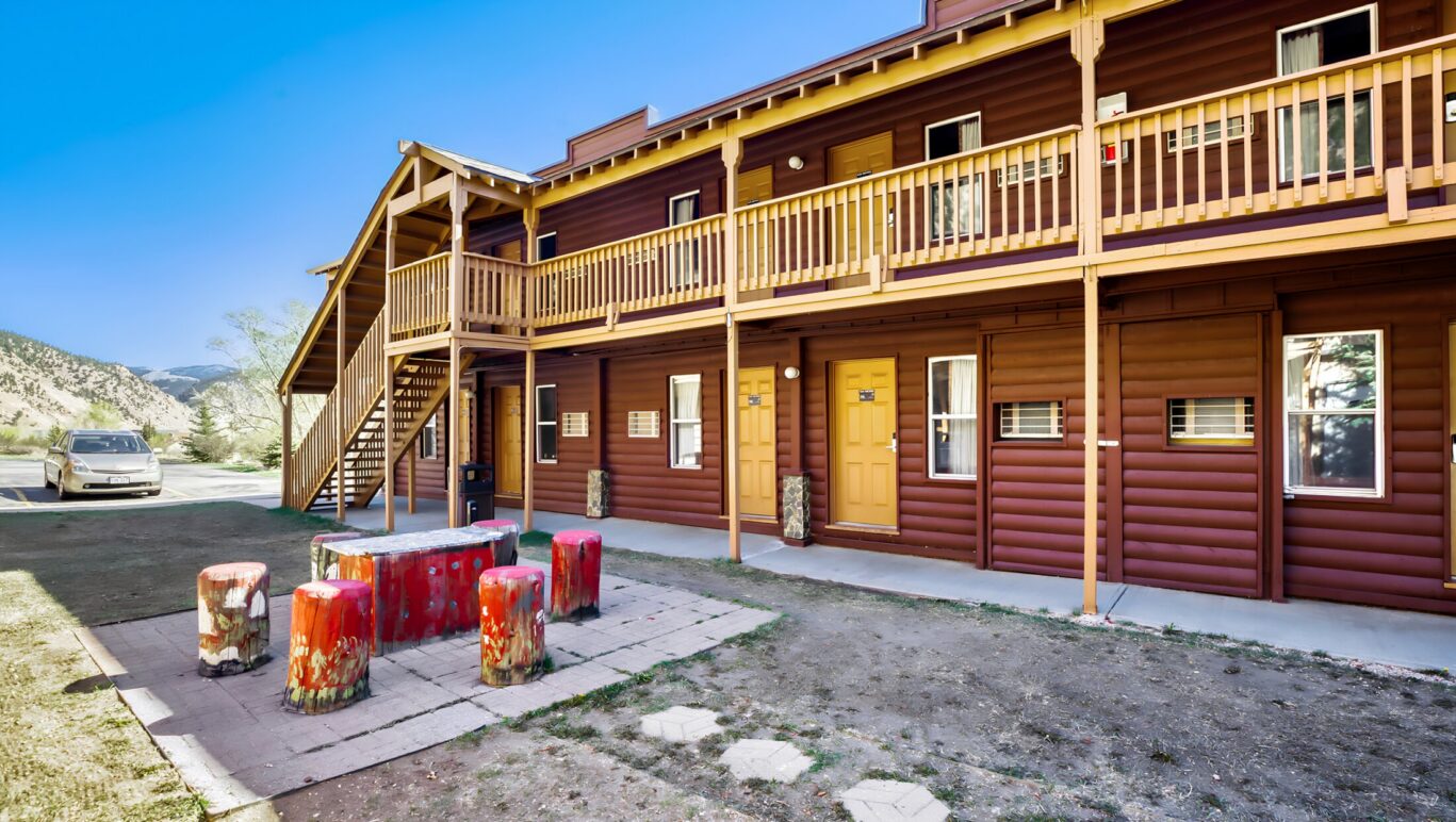 Exterior view of Georgetown Lodge guest rooms with outdoor seating area in Georgetown, Colorado.