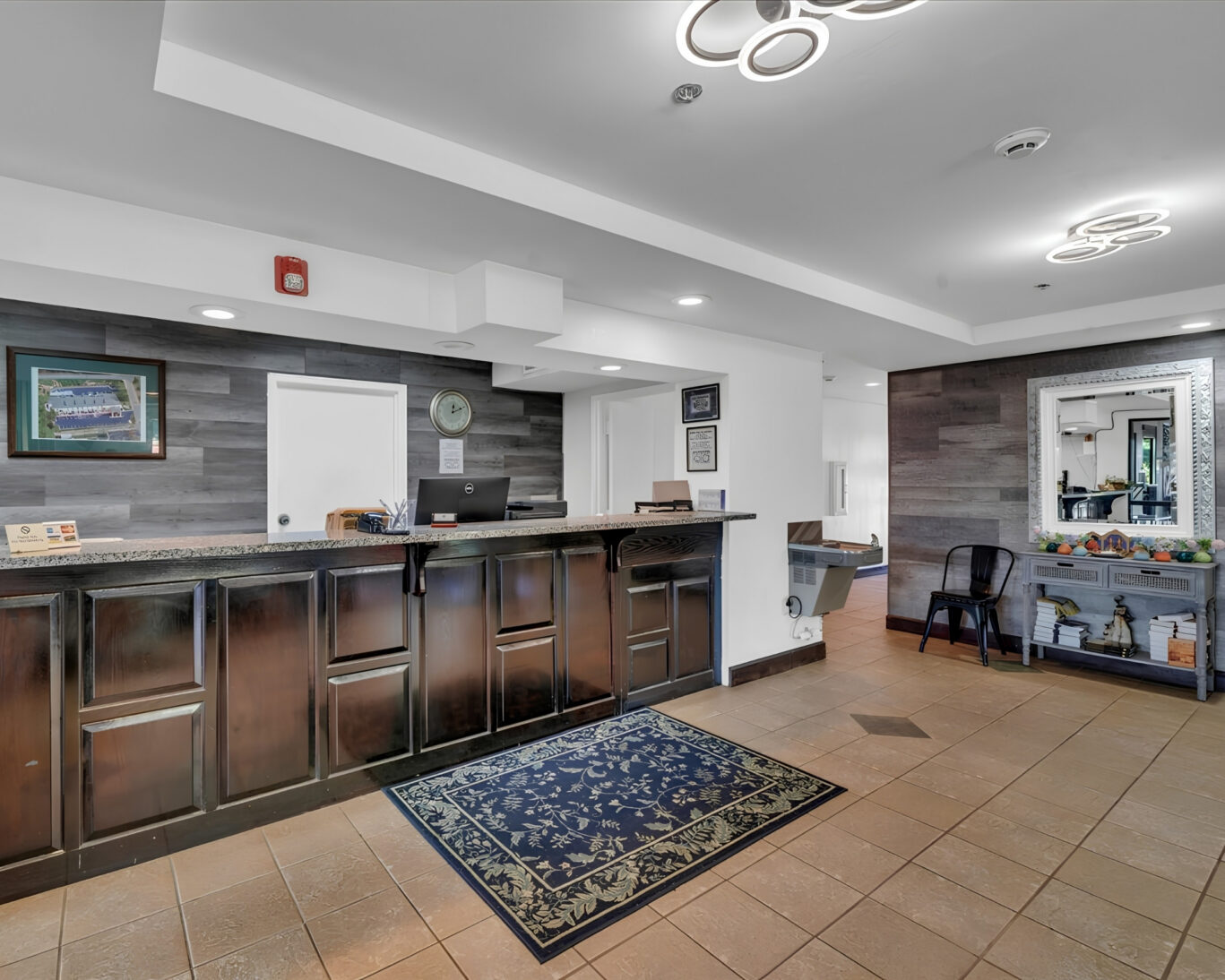 Front desk and lobby at Gray Inn and Suites with granite reception counter, tiled floor, and seating area.