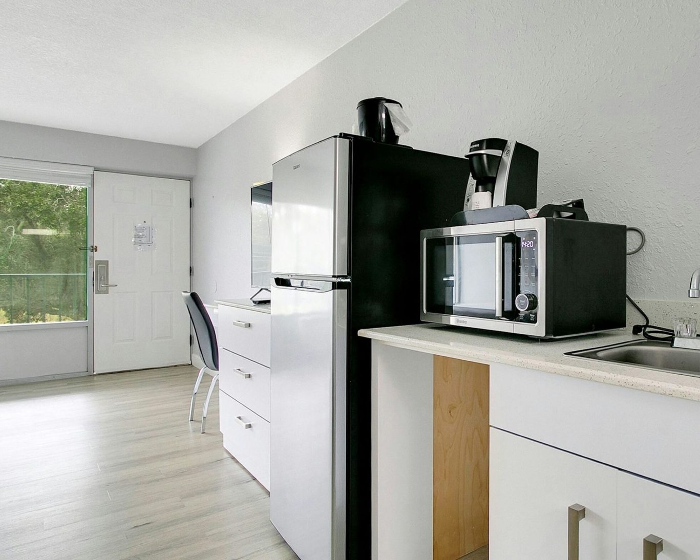 Modern in-room kitchenette with fridge, microwave, and coffee maker at H1 Extended Stay Kissimmee.