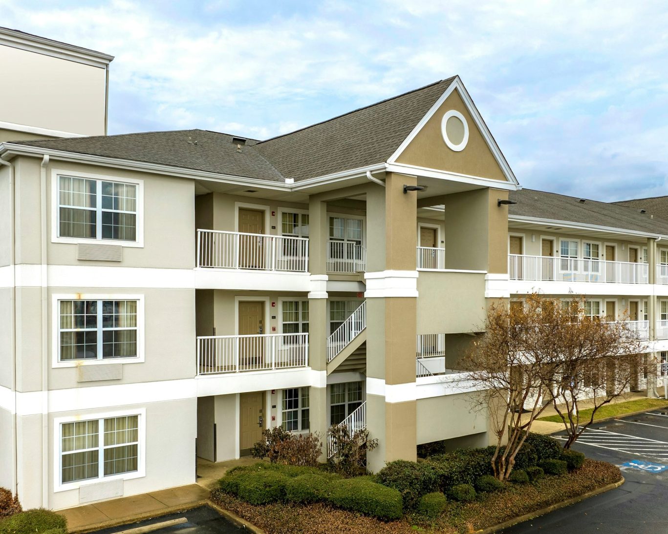 Exterior view of H1 Suites Montgomery showing guest room balconies and parking.