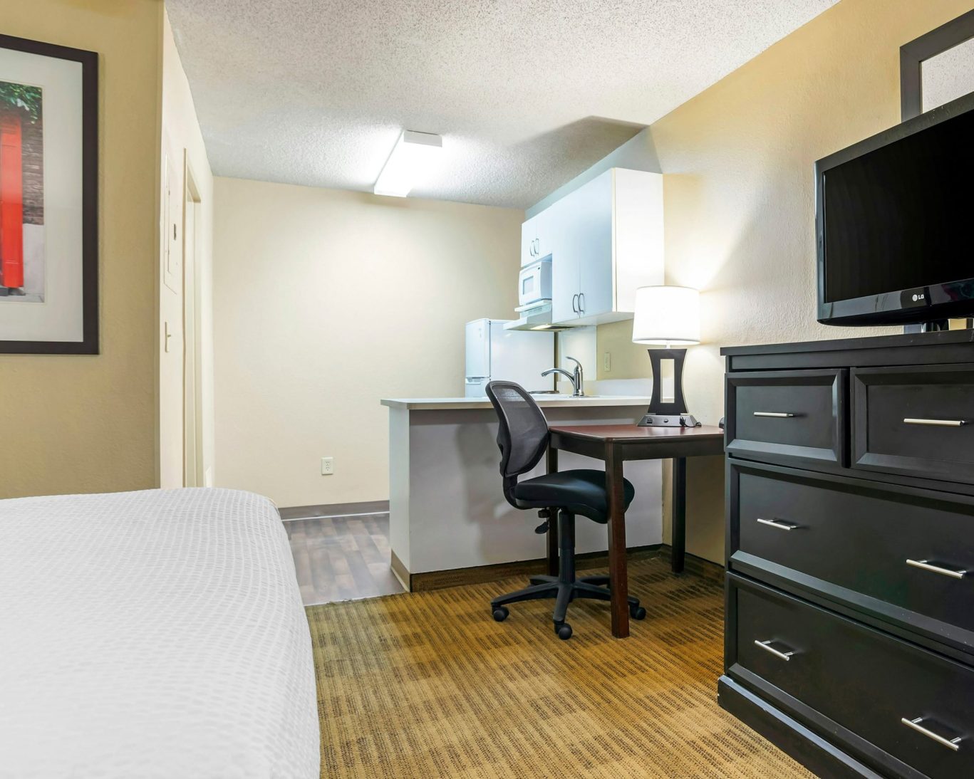 Studio suite interior with workspace and kitchenette at H1 Suites Montgomery.