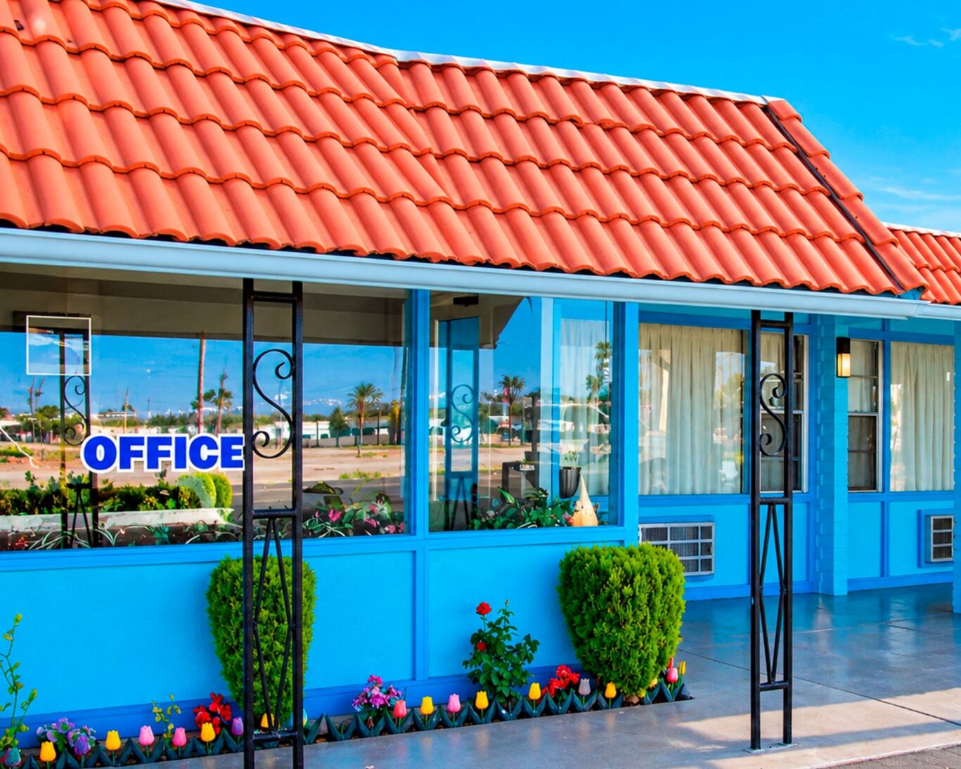 Blue Mist Motel office exterior with red tile roof and well-maintained landscaping.
