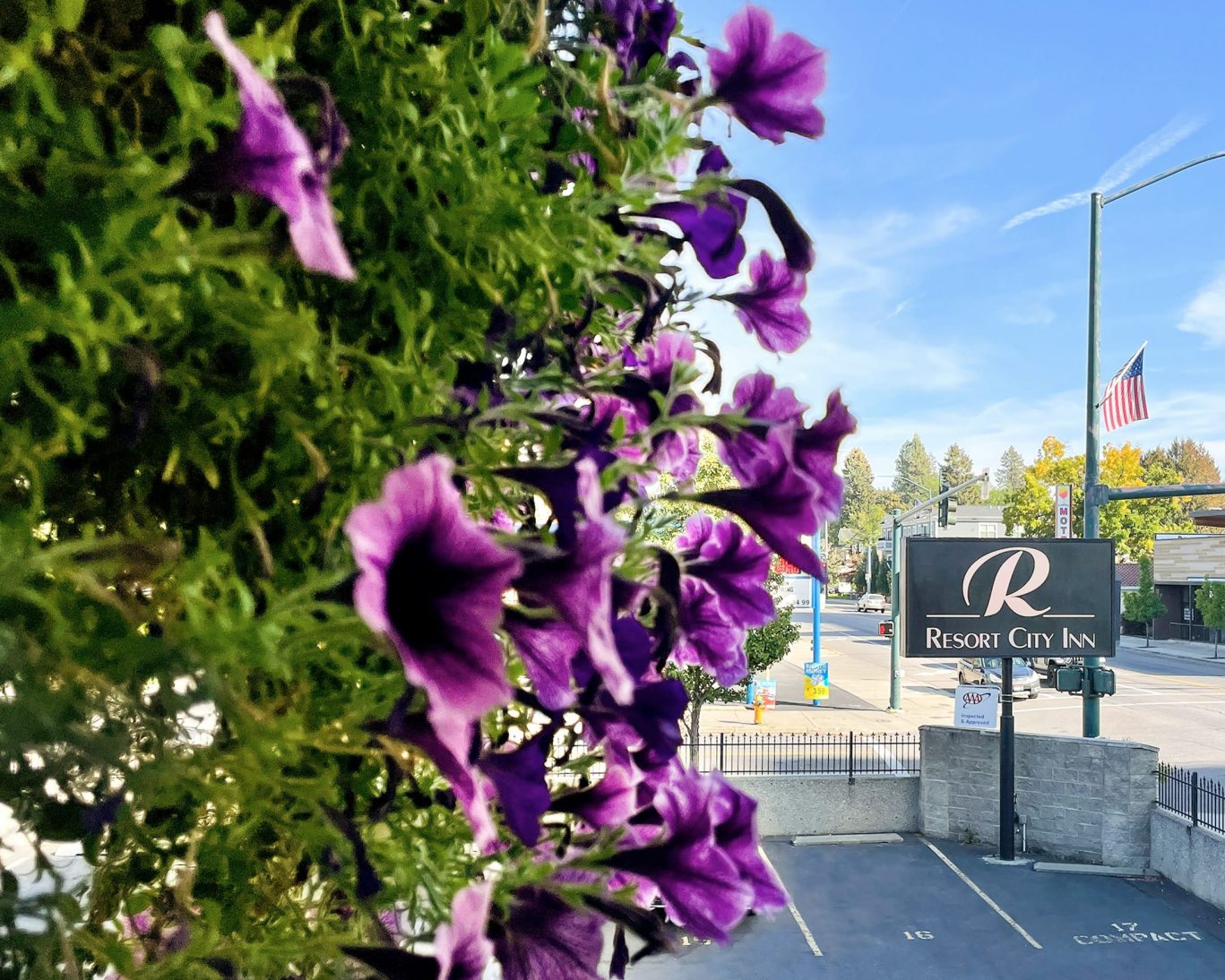 Exterior sign and parking area of Resort City Inn in downtown Coeur d'Alene with American flag visible.