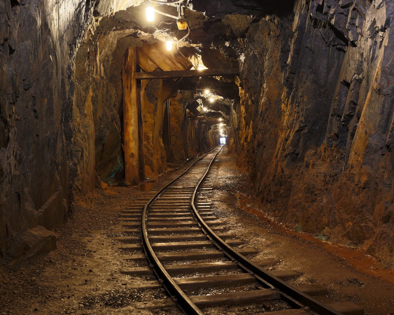 Underground mining tunnel with rail tracks and support beams at Cliffs Shaft Mine Museum in Ishpeming, Michigan.