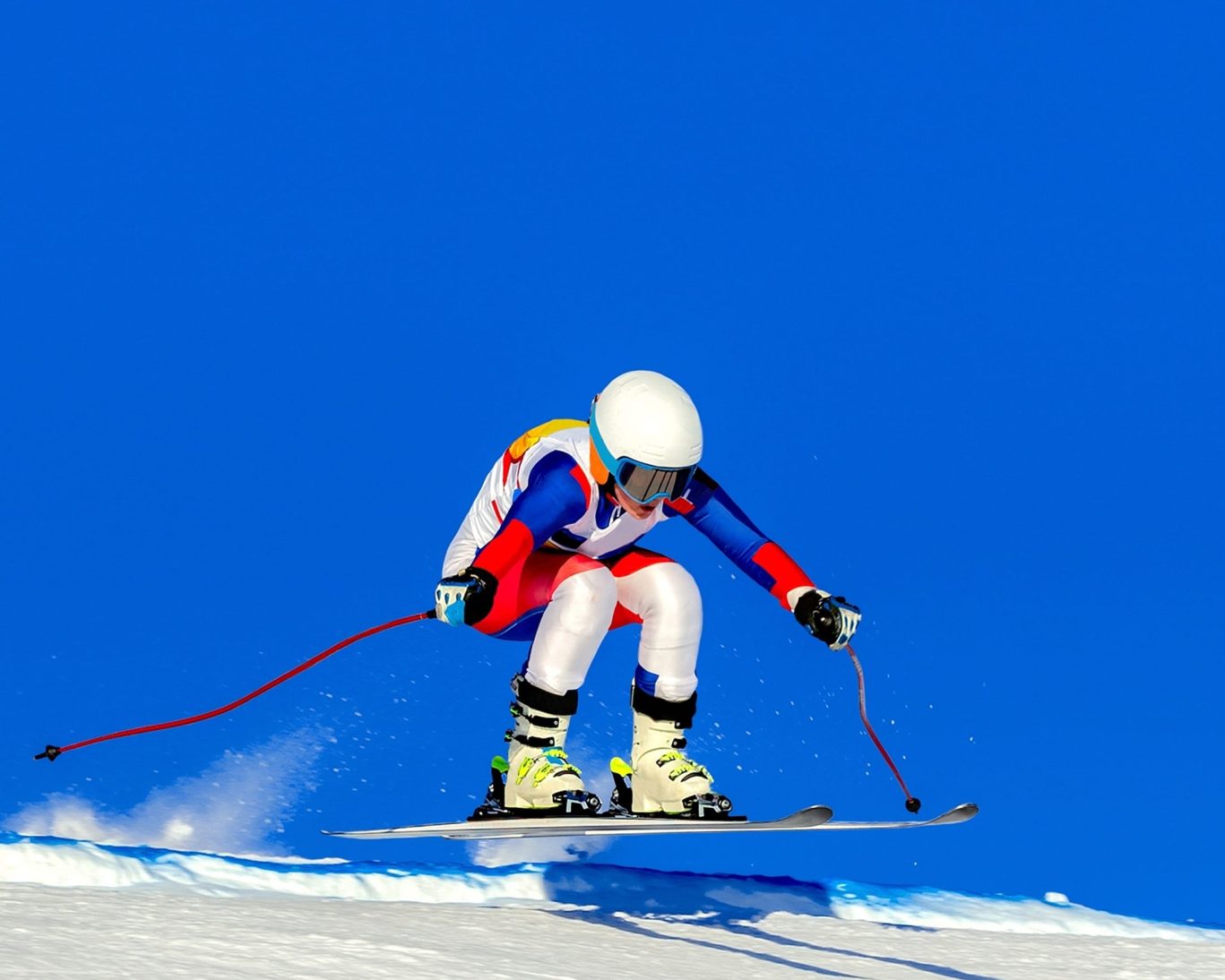 Vibrant fall foliage along the rocky shoreline of Lake Superior under a bright blue sky in Michigan’s Upper Peninsula.
