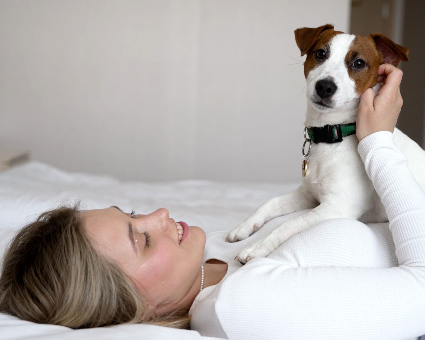 Guest relaxing with a small dog on the bed in a pet-friendly room at Jasper Ridge Inn.