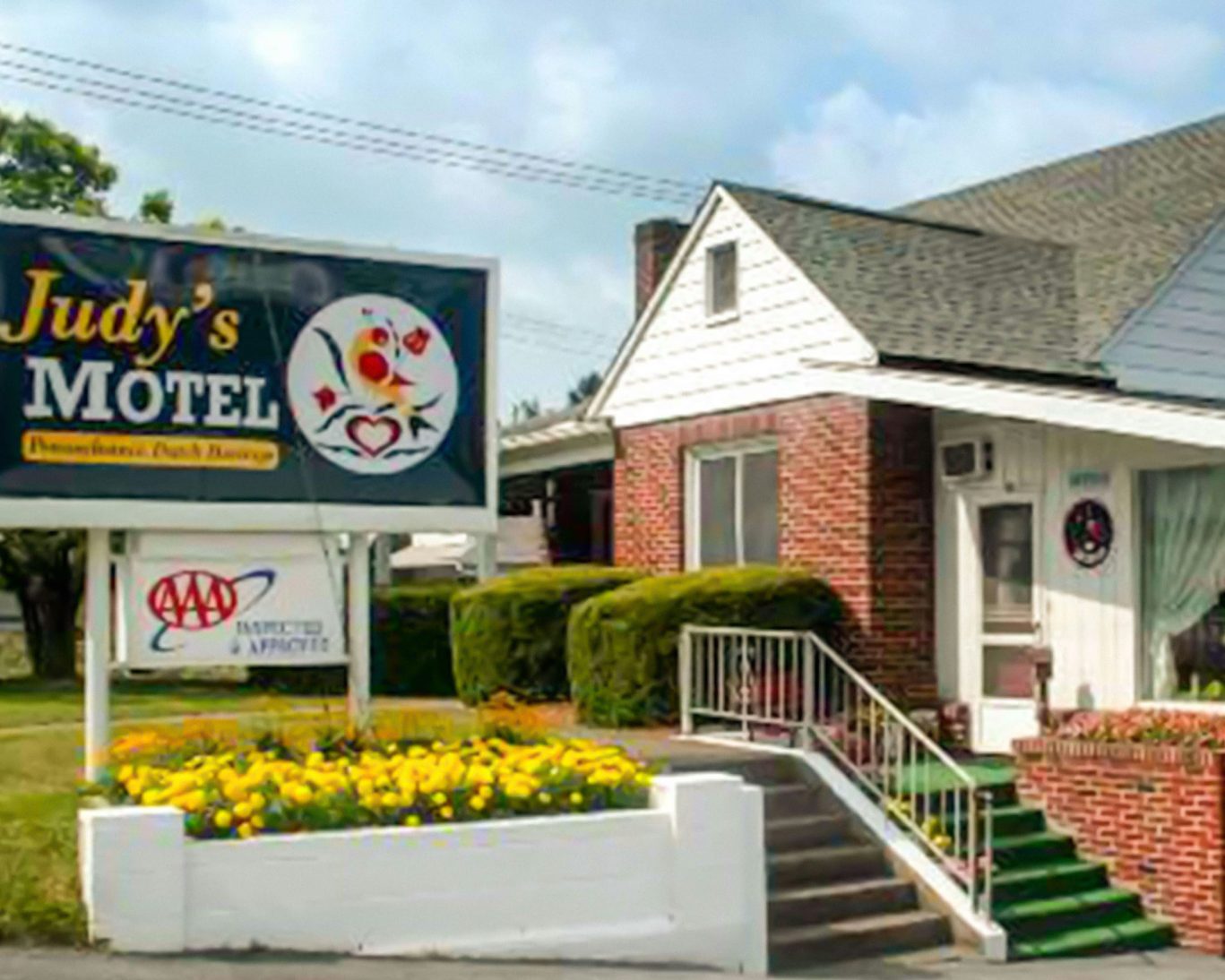 Exterior view of Judy's Motel in Bedford PA with Dutch-themed sign and well-kept landscaping.