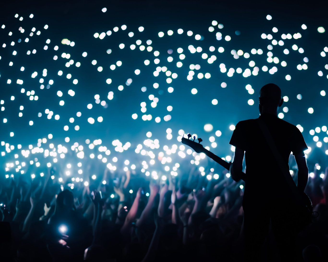 Live concert at SoFi Stadium Inglewood with crowd and performer under stage lights.