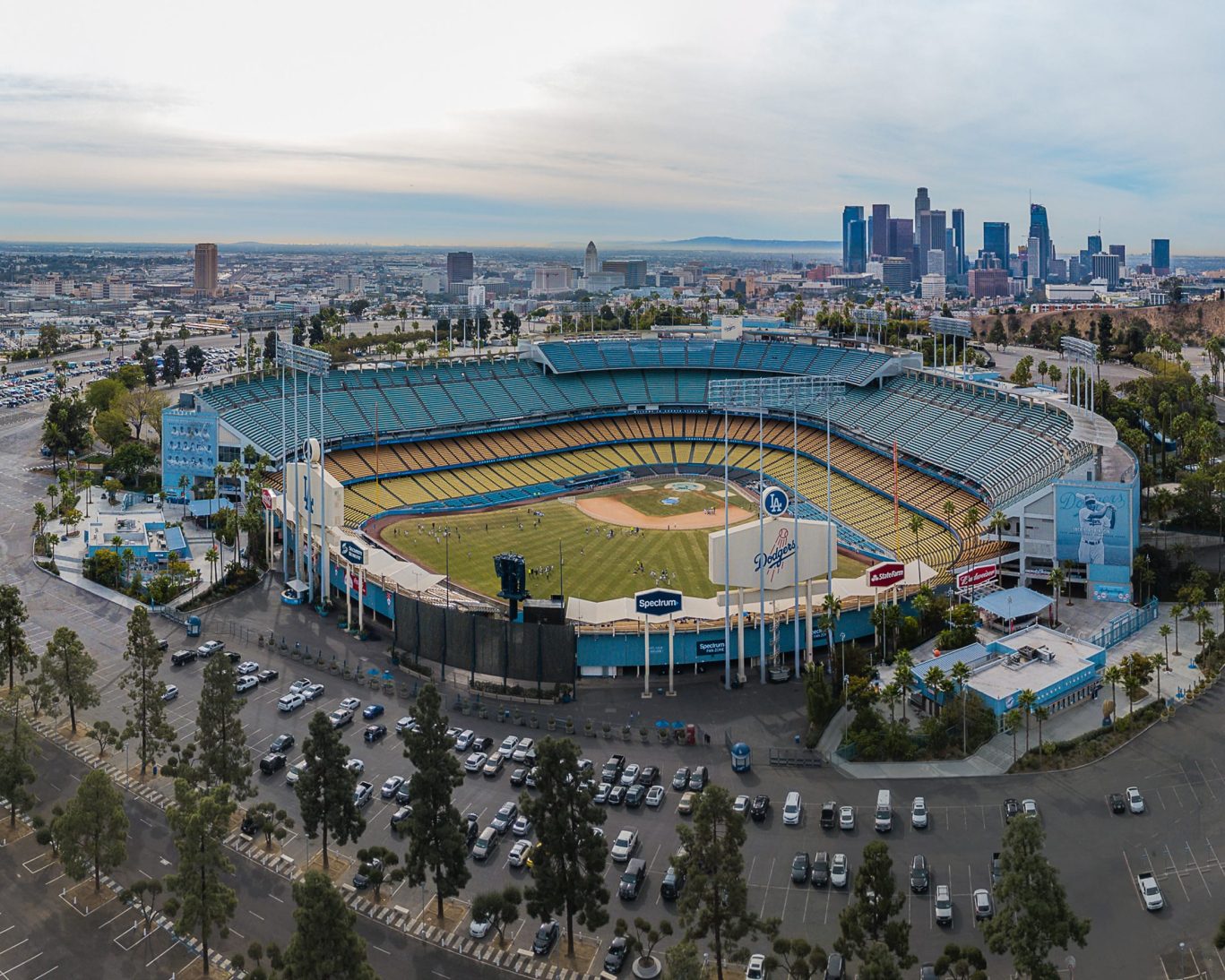 Aerial view of Dodger Stadium with downtown Los Angeles skyline in the background.