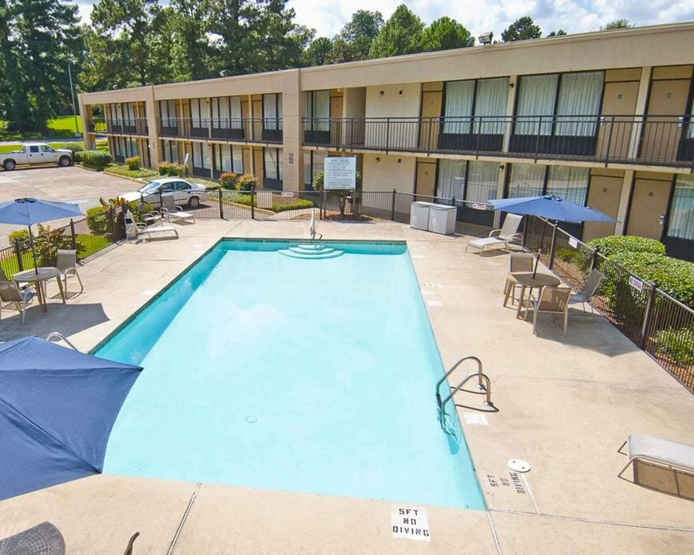 Outdoor swimming pool with lounge chairs and surrounding guest rooms at The Hotel Francis.