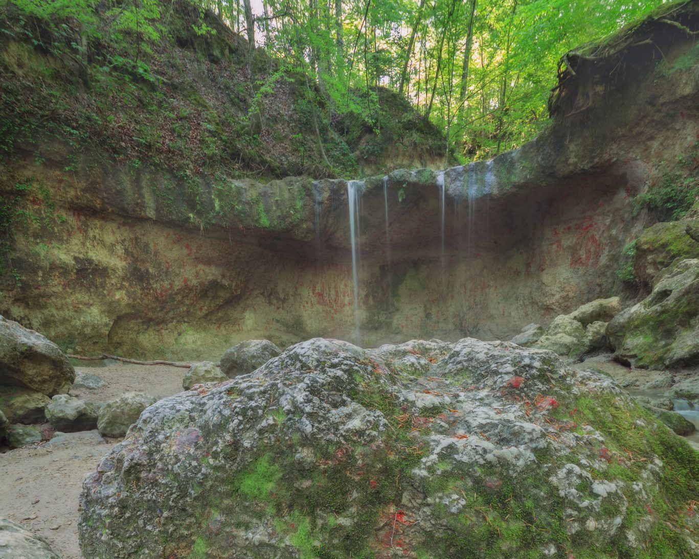Scenic view of cascading waterfall and moss-covered rocks in Tunica Hills Wildlife Area, Louisiana.