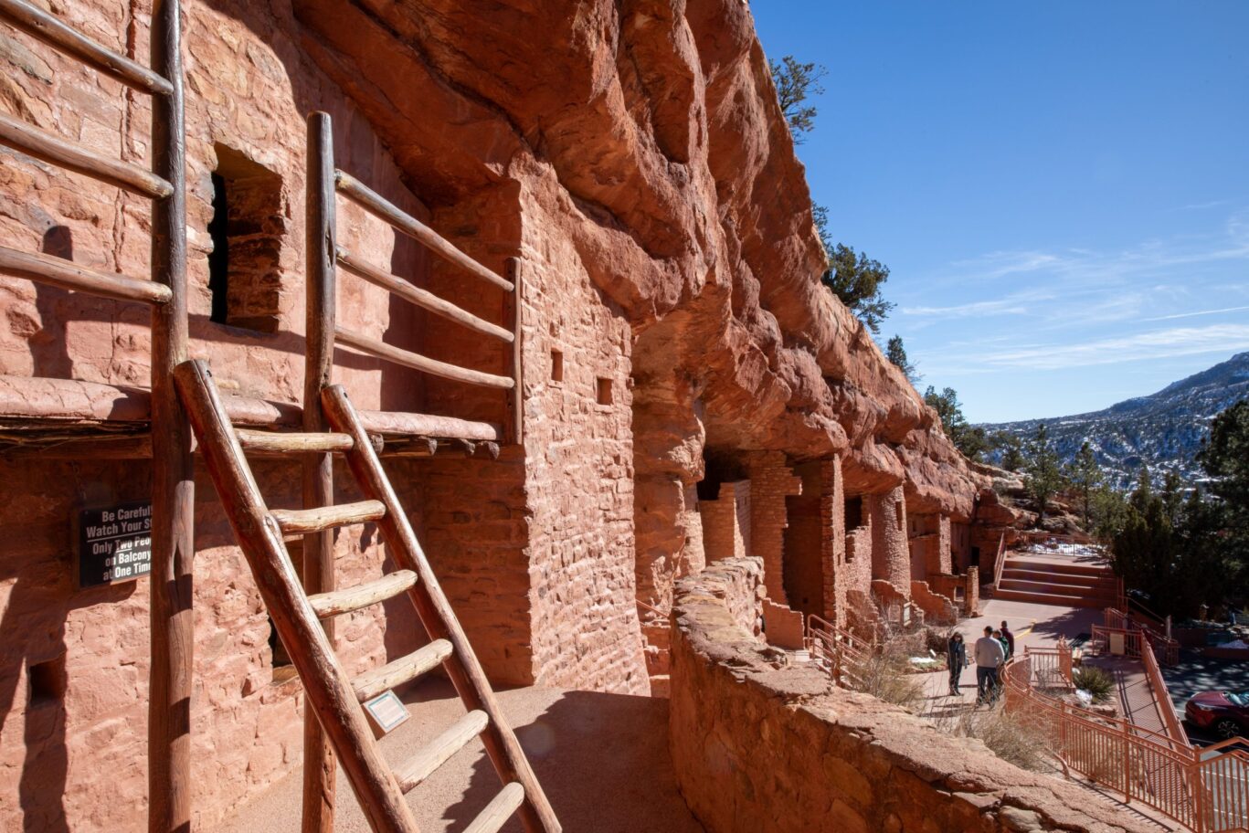 Close-up of ancient stone dwellings and wooden ladder at Manitou Cliff Dwellings in Colorado.
