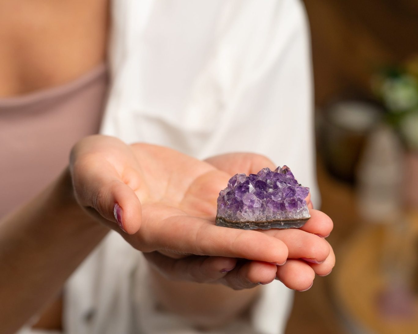Close-up of a person holding a raw amethyst gemstone at the Deutsches Edelsteinmuseum in Idar-Oberstein, Germany.