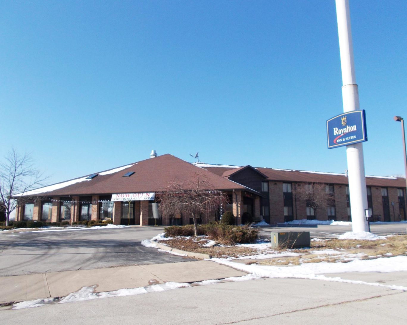 Royalton Inn & Suites Wilmington exterior with sign and snow-covered landscaping.