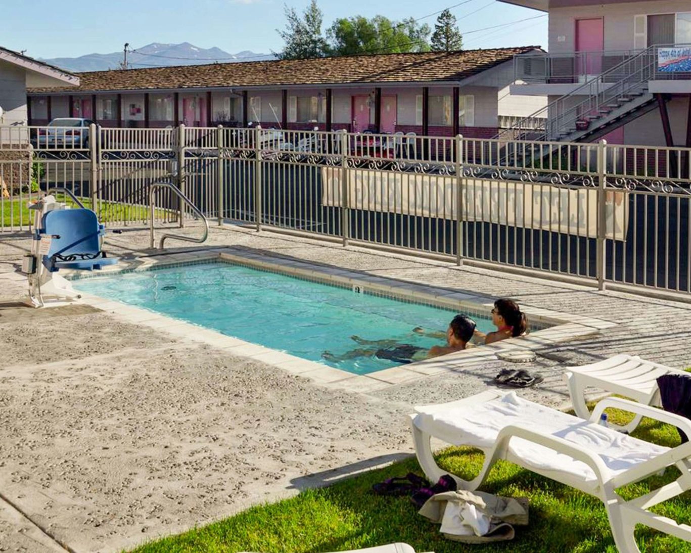 Outdoor heated pool at Ruby Inn Bridgeport with lounge chairs and scenic mountain backdrop.
