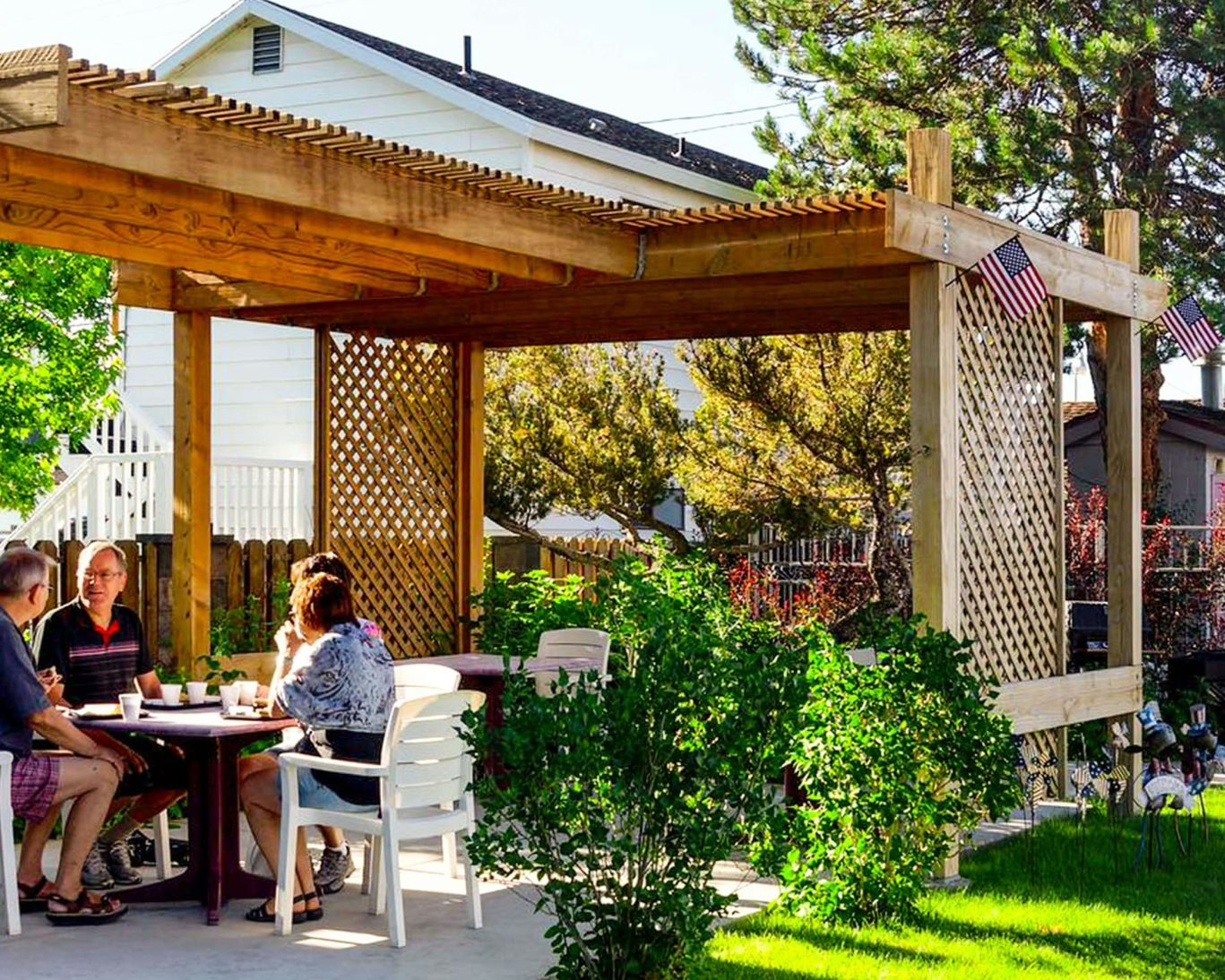 Guests enjoying outdoor breakfast under a wooden pergola at Ruby Inn Bridgeport.