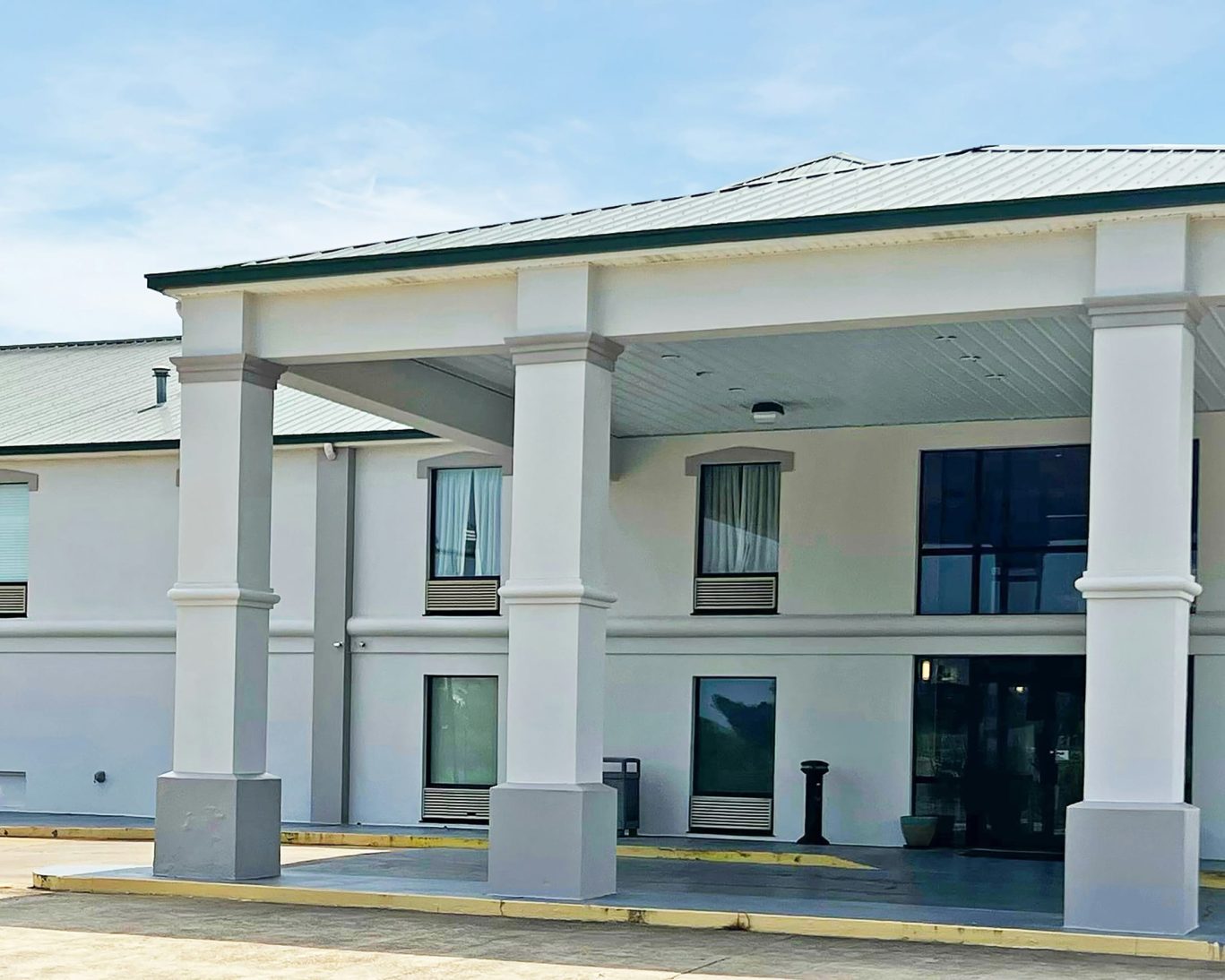 Front entrance of Super Inn and Suites Philadelphia with modern white facade and covered driveway.