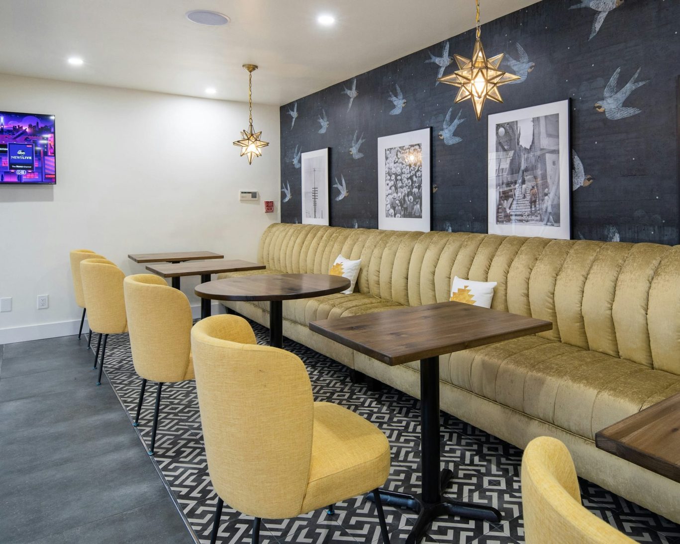 Trendy indoor seating area at The Catrina Hotel featuring gold tufted bench and star-shaped lighting