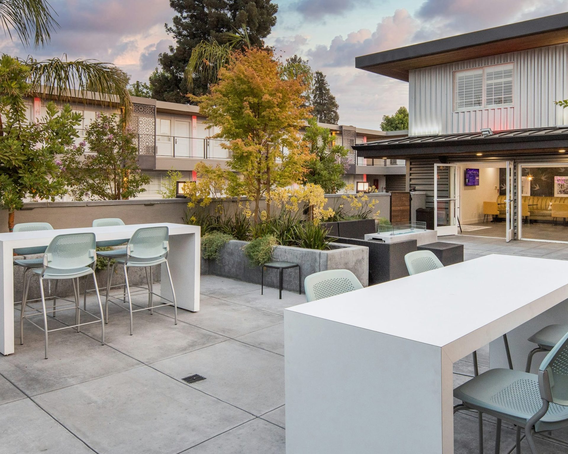 Outdoor courtyard at The Catrina Hotel with modern dining tables and landscaped greenery