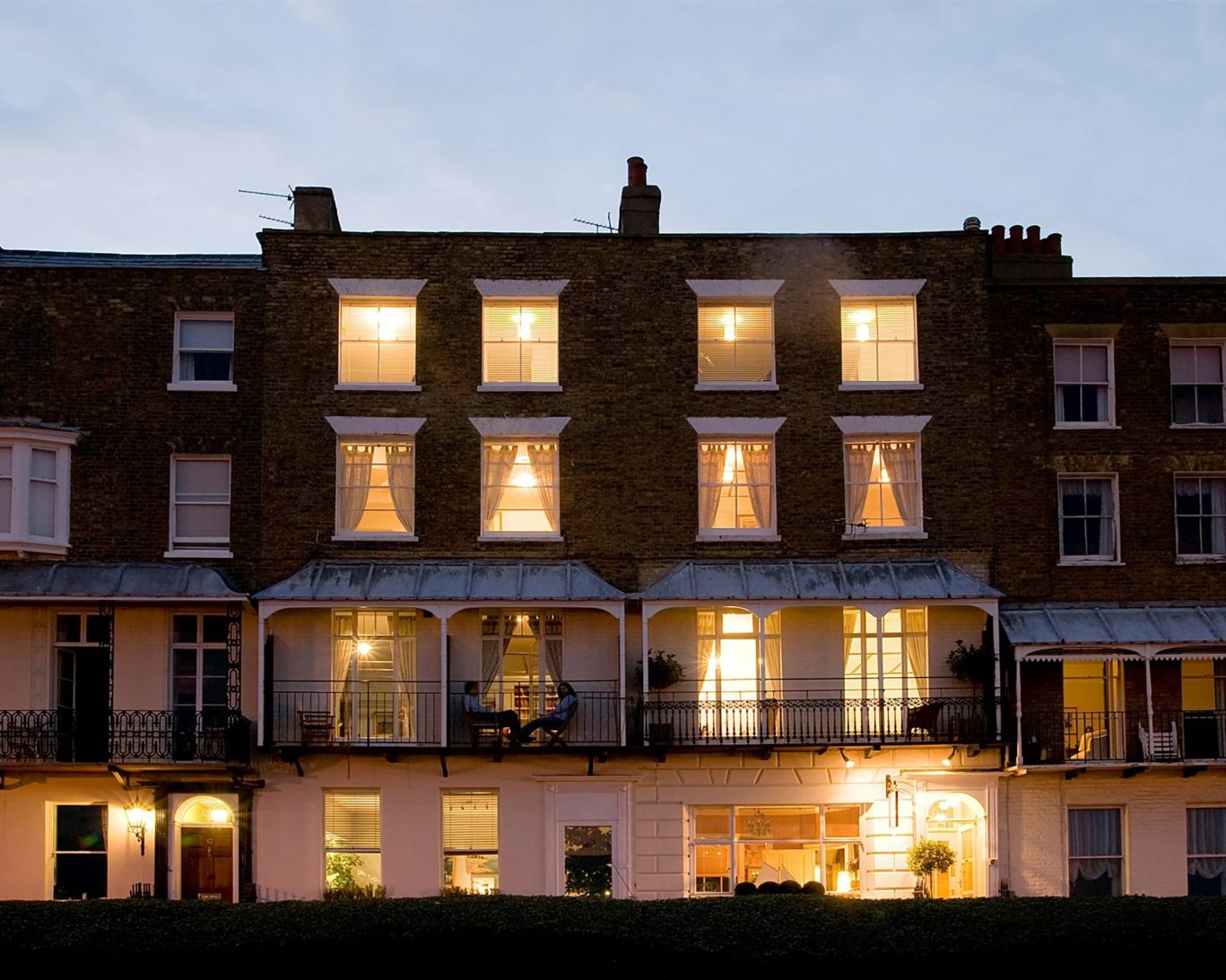 Warmly lit Georgian facade of The Royal Harbour Hotel Ramsgate in the evening.