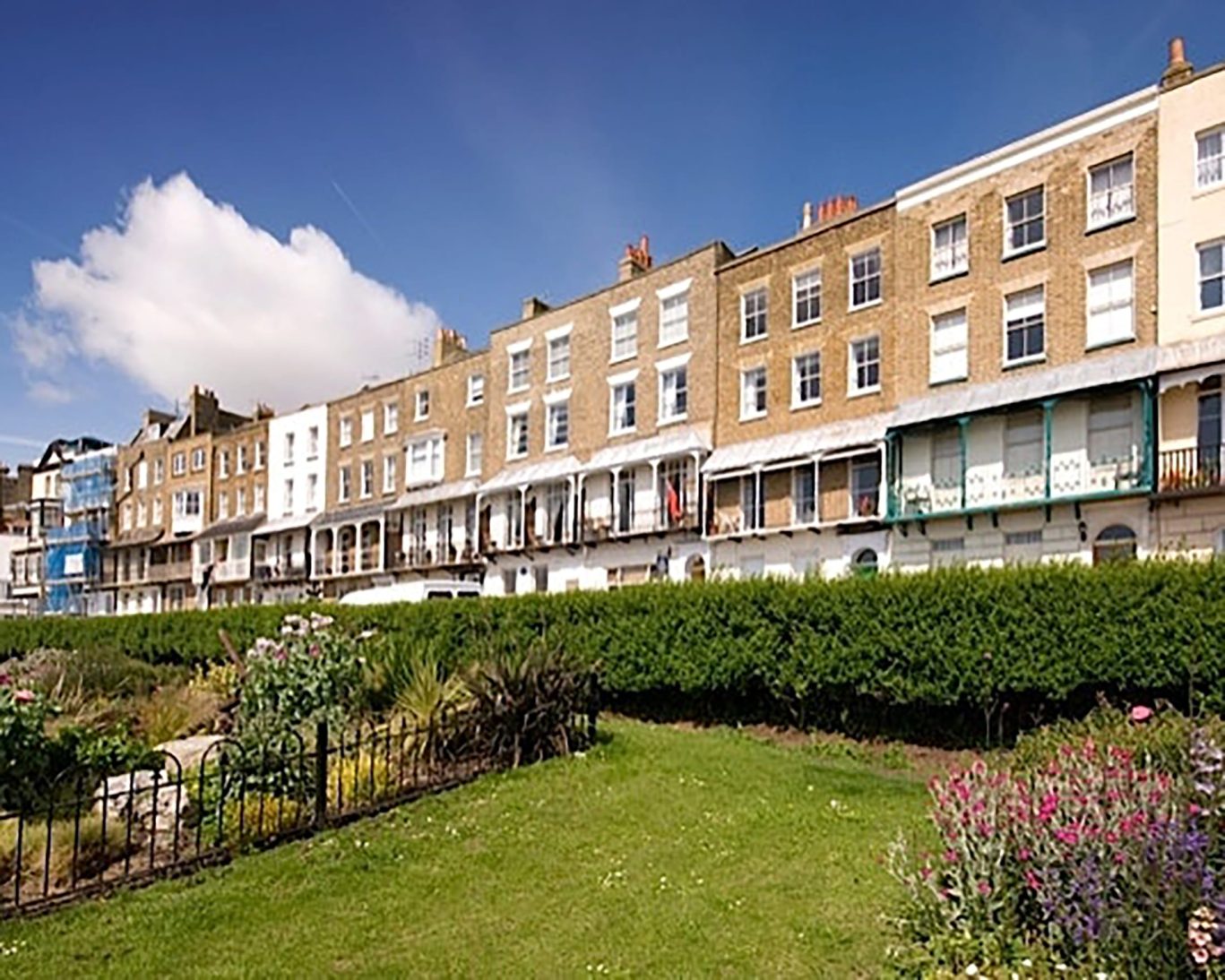 Seafront view of The Royal Harbour Hotel Ramsgate with Georgian architecture and garden in foreground.