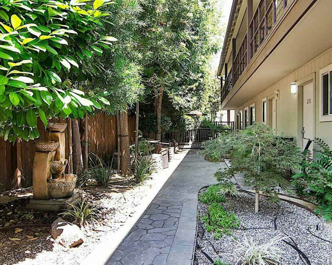 Peaceful Zen Hotel walkway with landscaped garden and water fountain in Palo Alto, California
