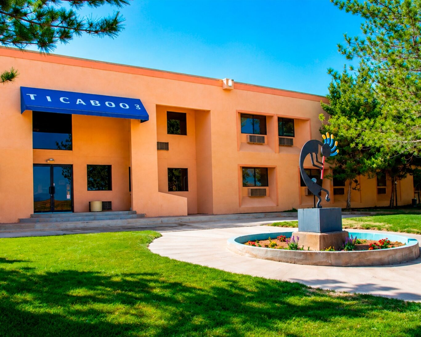 Front view of Ticaboo Lodge with southwestern architecture and courtyard sculpture.