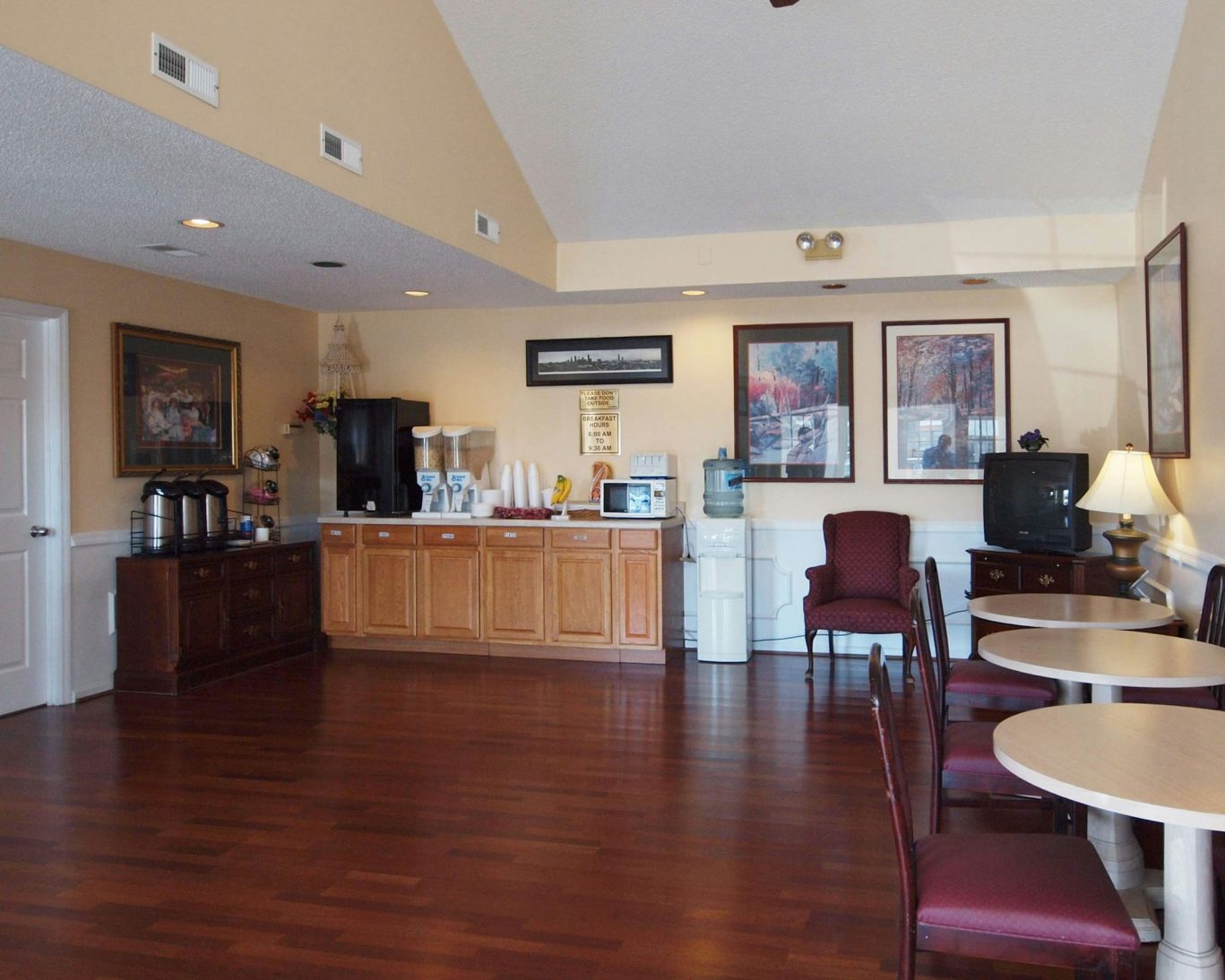 Western Motel Fitzgerald breakfast area with coffee station, seating, and wood flooring