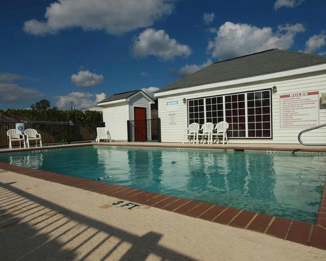 Outdoor swimming pool at Western Motel Fitzgerald with lounge chairs and safety signage