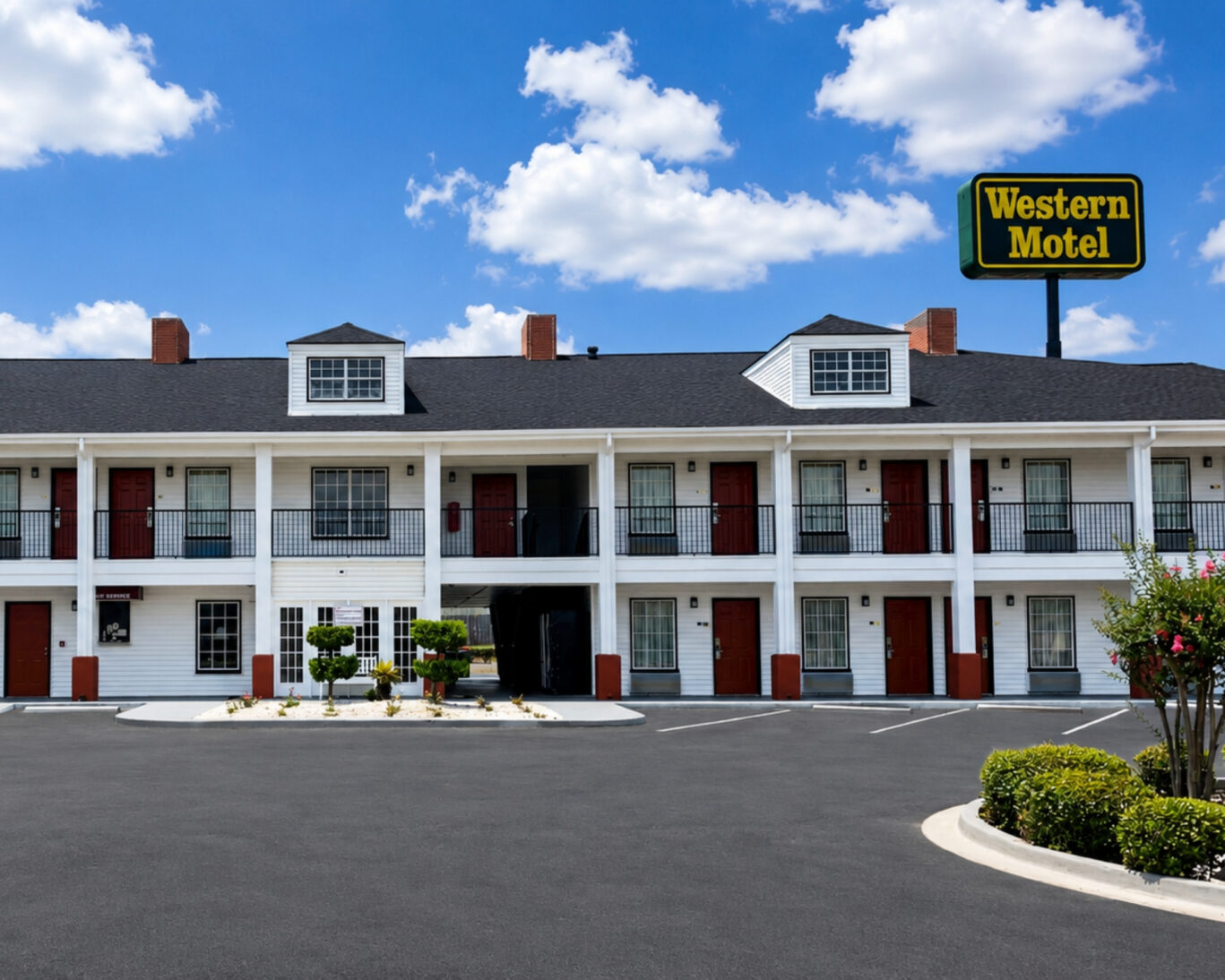 Front view of Western Motel showing the roadside sign, two-story guest room block, and parking lot.