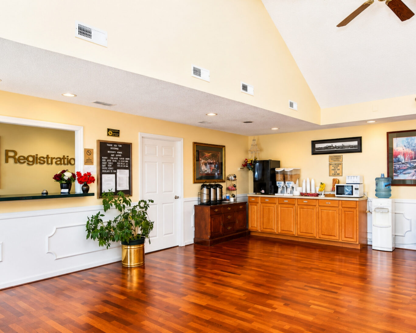 Registration desk at Western Motel with signed counter, refreshment station, and hardwood lobby floor.