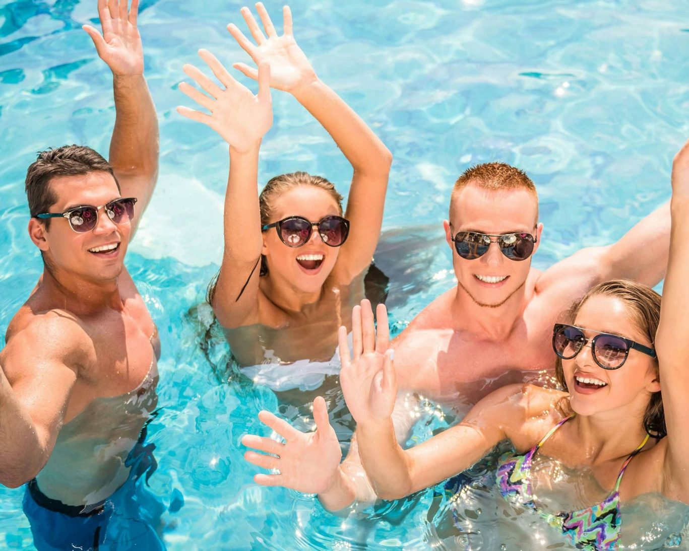 Group of friends enjoying the outdoor swimming pool at Western Motel on a sunny day.