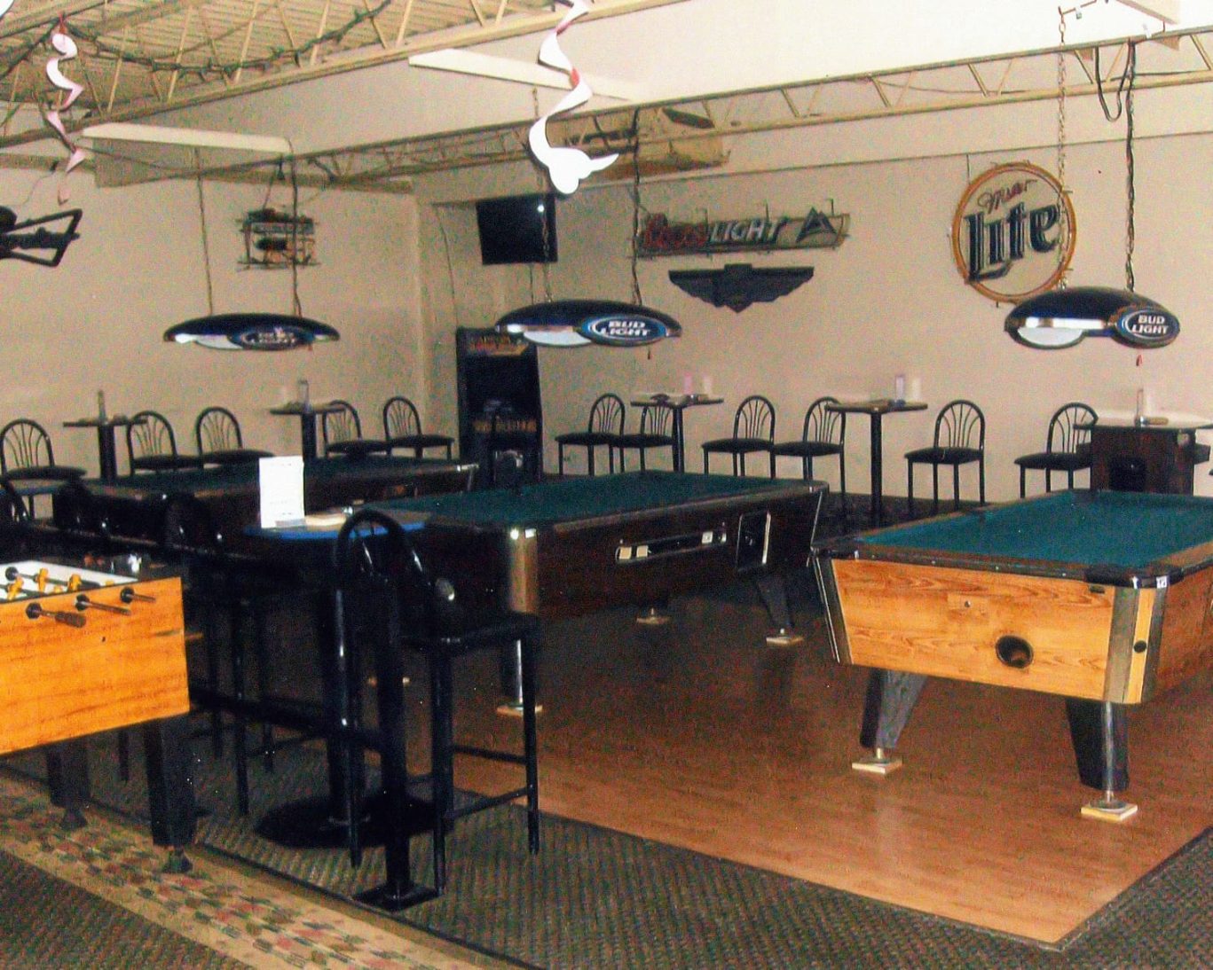 Game room at Will Rogers Inn featuring pool tables, foosball, and bar seating.