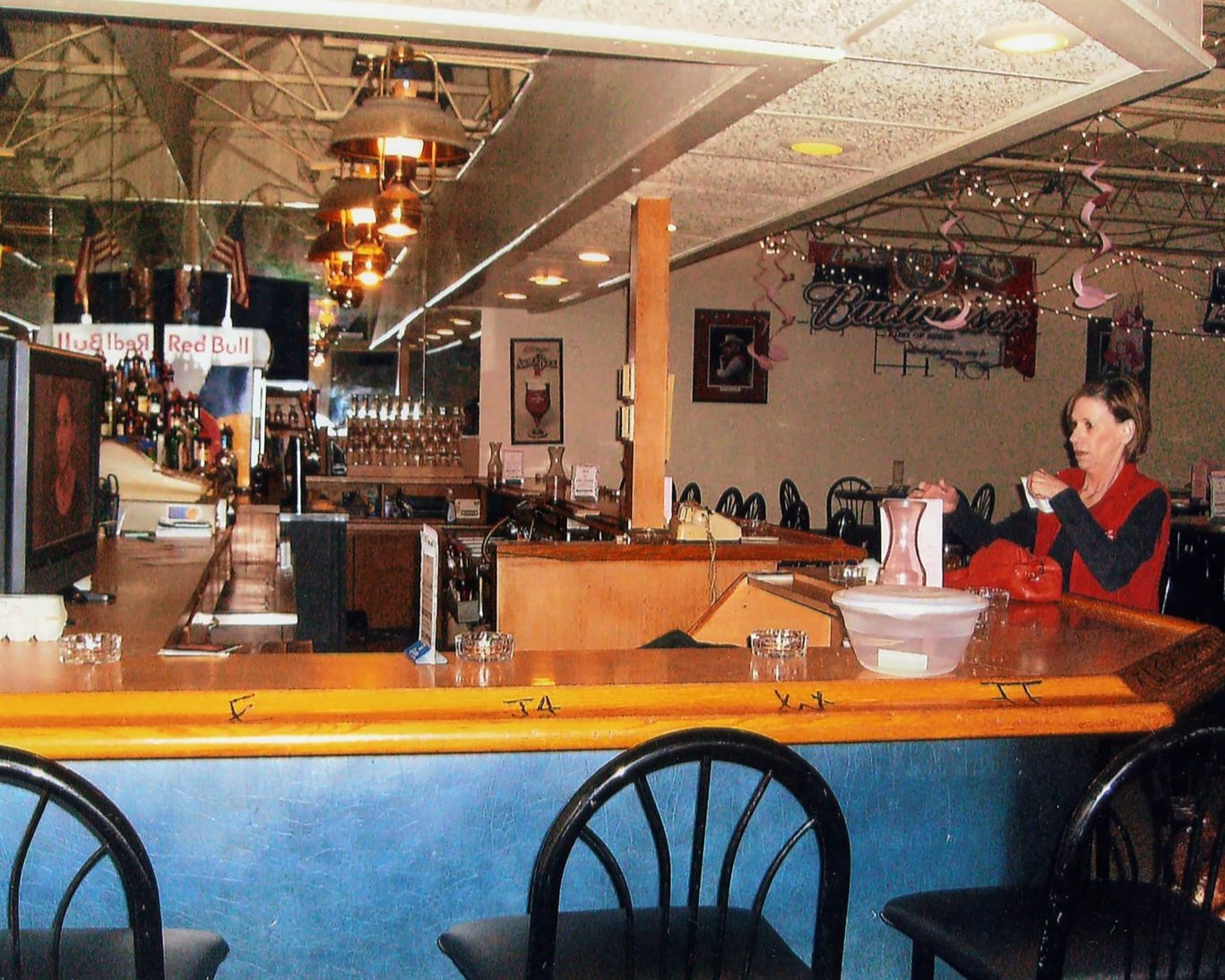 Cozy bar area at Will Rogers Inn with bartender and rustic decor.