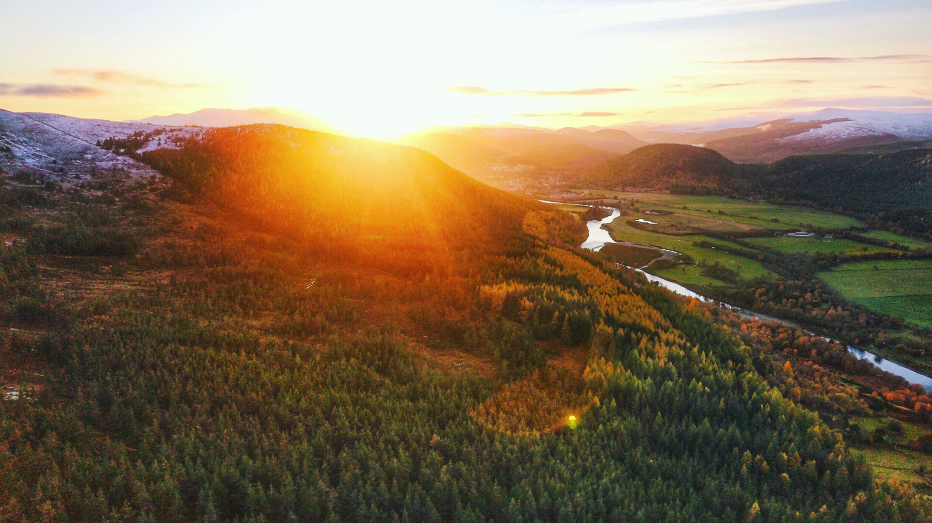 Aerial sunset view over forested hills and river valley in Royal Deeside, Aberdeenshire, Scotland