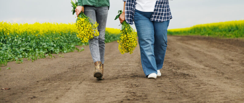 women on a walk with freshly picked flowers outside