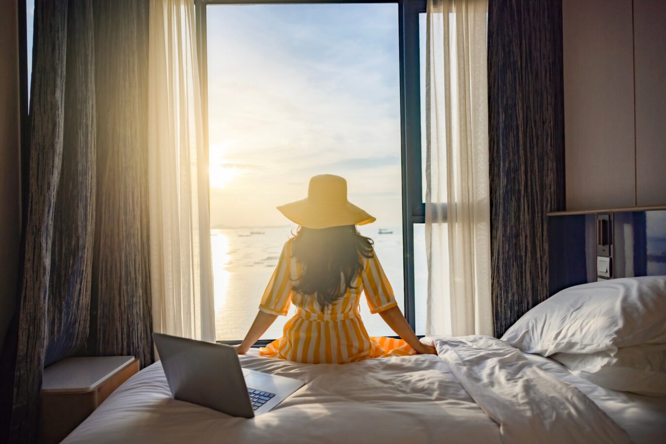 Tourist,Woman,Sitting,On,Bed,Nearly,Window,,Looking,To,Beautiful